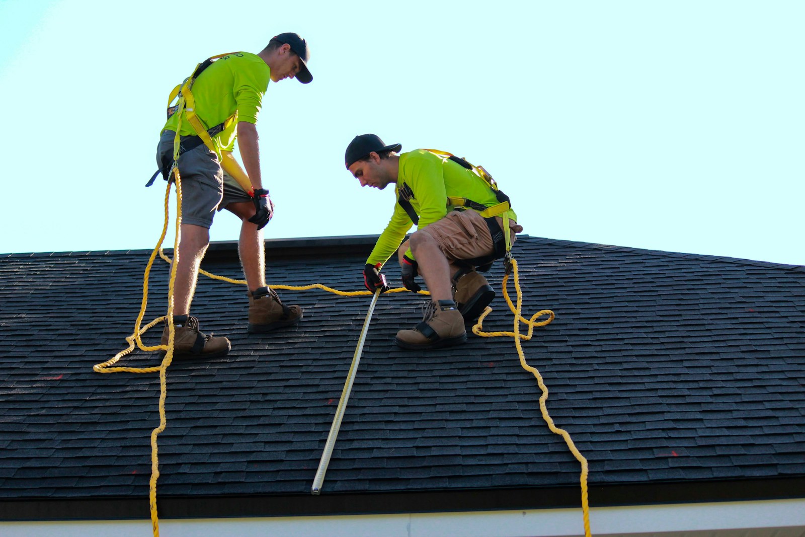 Photo by Raze Solar a couple of people that are on a roof